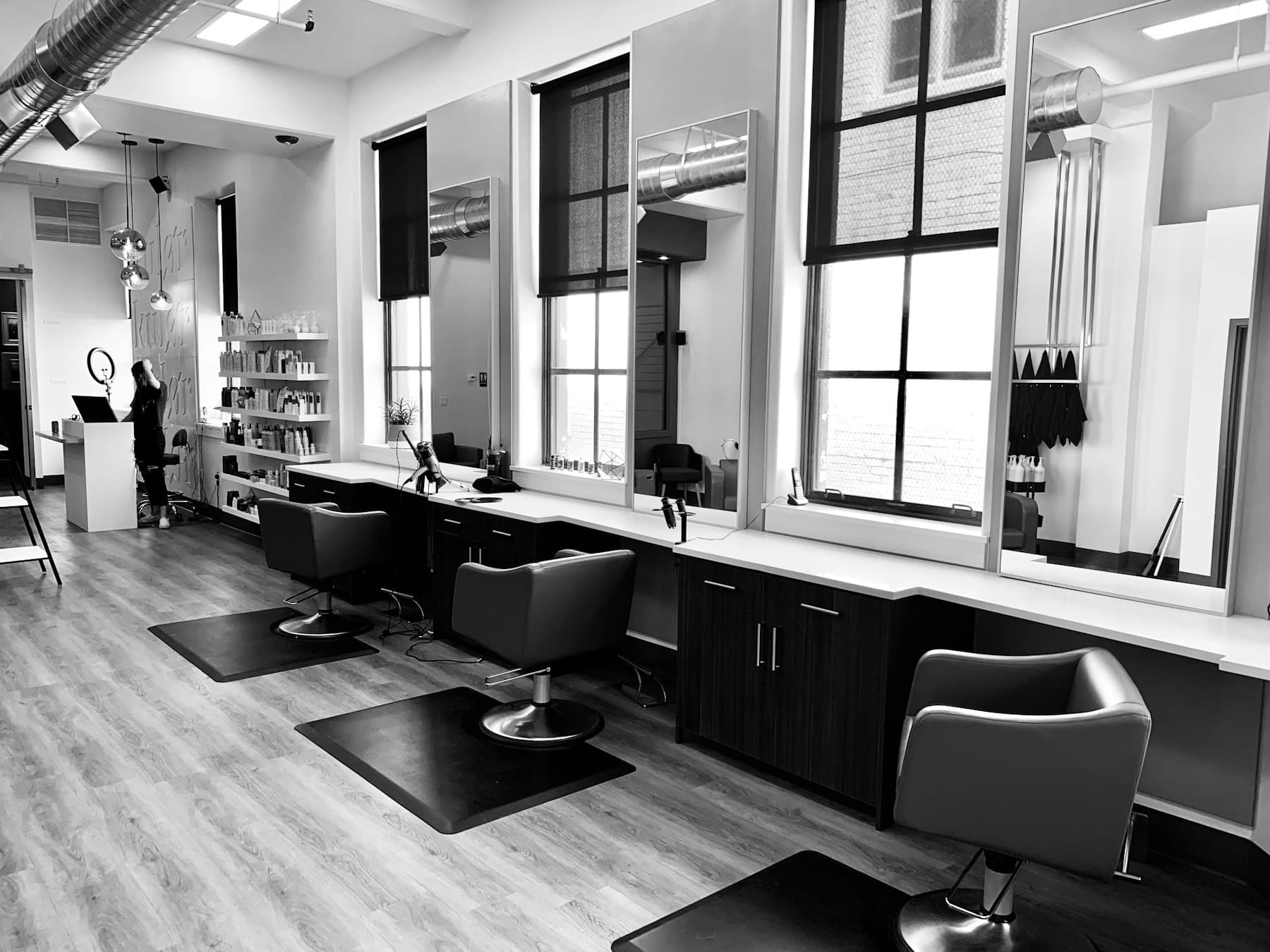 Black-and-white salon interior with styling chairs and wall mirrors